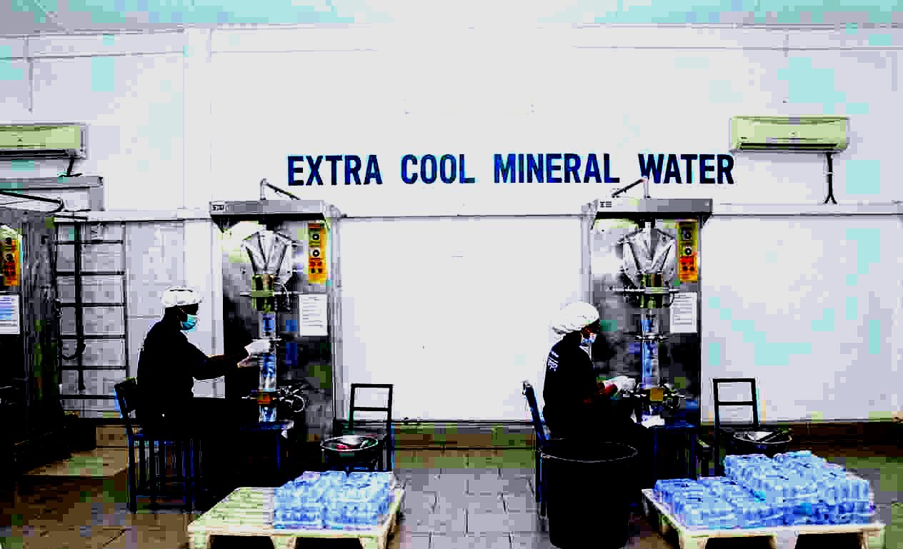 Extra Cool Mineral Water team operating the sachet production machines